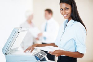 smiling professional at a business printer