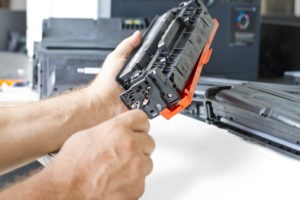 a pair of hands repairing a printer cartridge