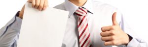 a business professional holding up a piece of paper in one hand giving the thumbs up sign with the other