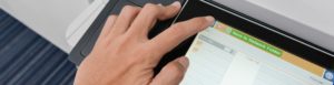 a hand at a printer touchpad interface