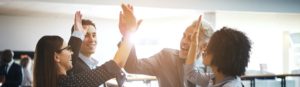 Four employees high-fiving