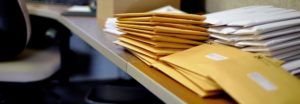A stack of envelopes on a desk in an office