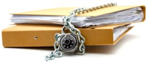 A folder full of paper documents with a chain and padlock around it